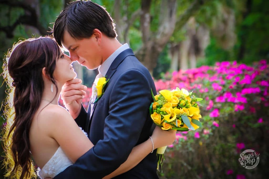 Sugar Pop Productions - groom holding bride's chin in garden setting