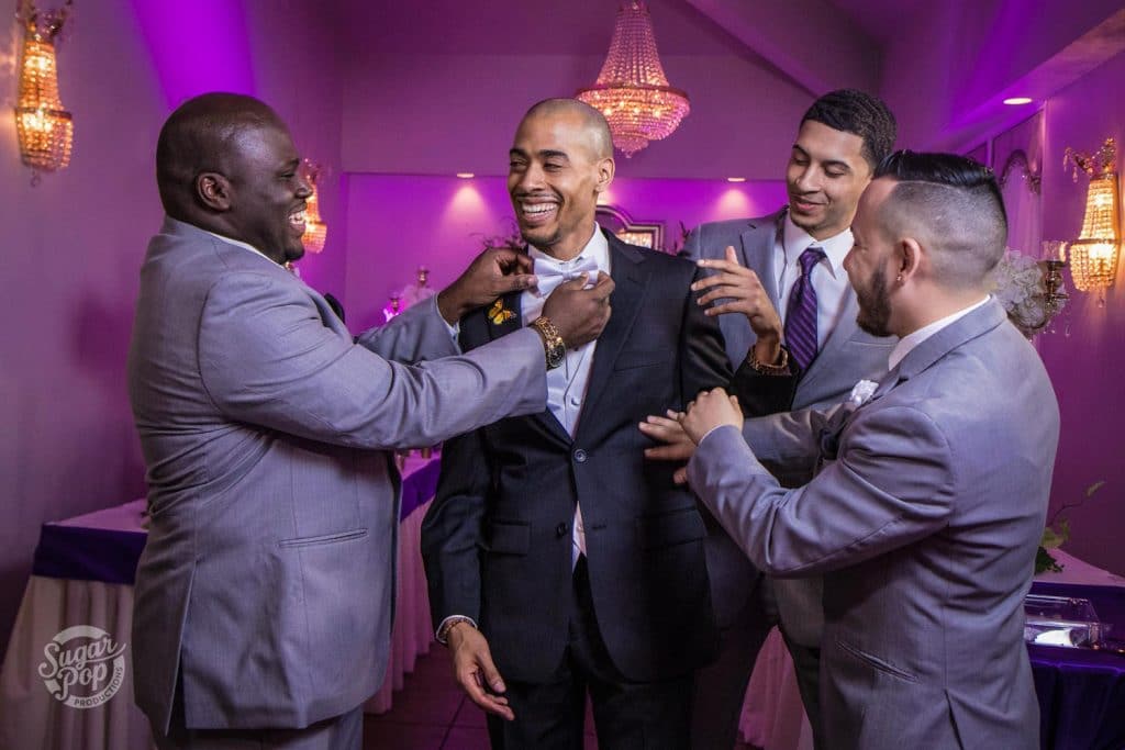 Sugar Pop Productions - groomsmen adjusting groom's suit