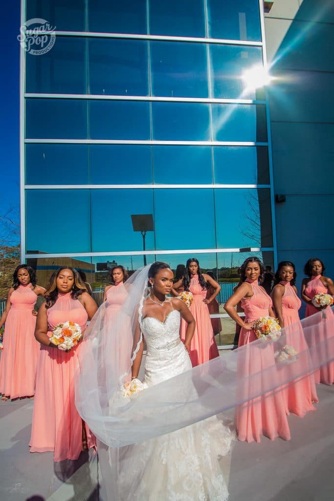 Sugar Pop Productions - bride and bridesmaids in front of windowed building
