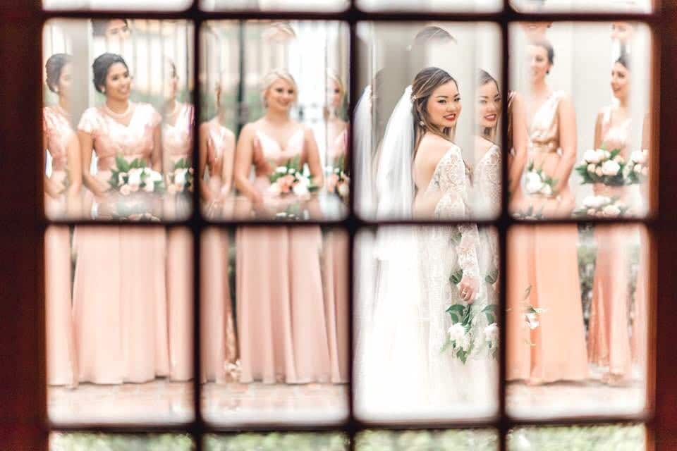 That First Moment - view of bridal party through beveled panes of glass