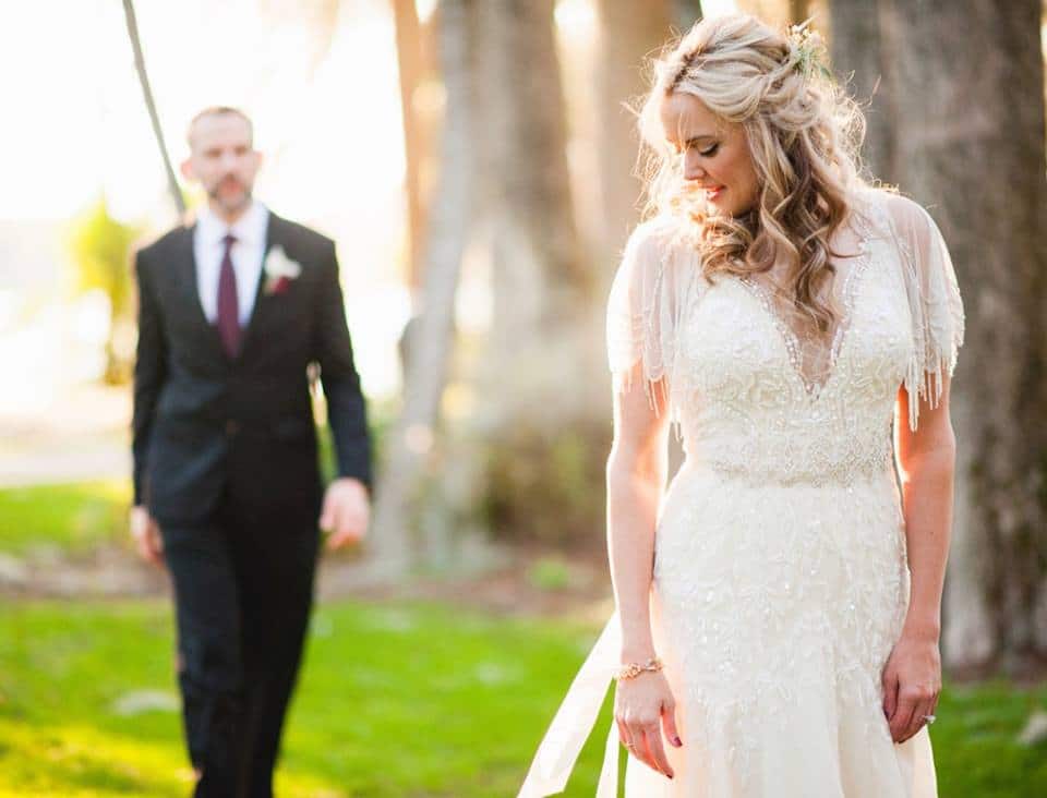 That First Moment - bride in stunning beaded dress with groom in background