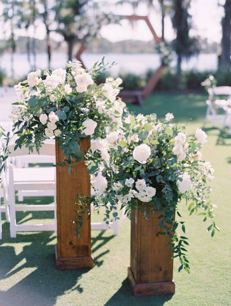 Wedding wood pillars with flower atop and lake in the background