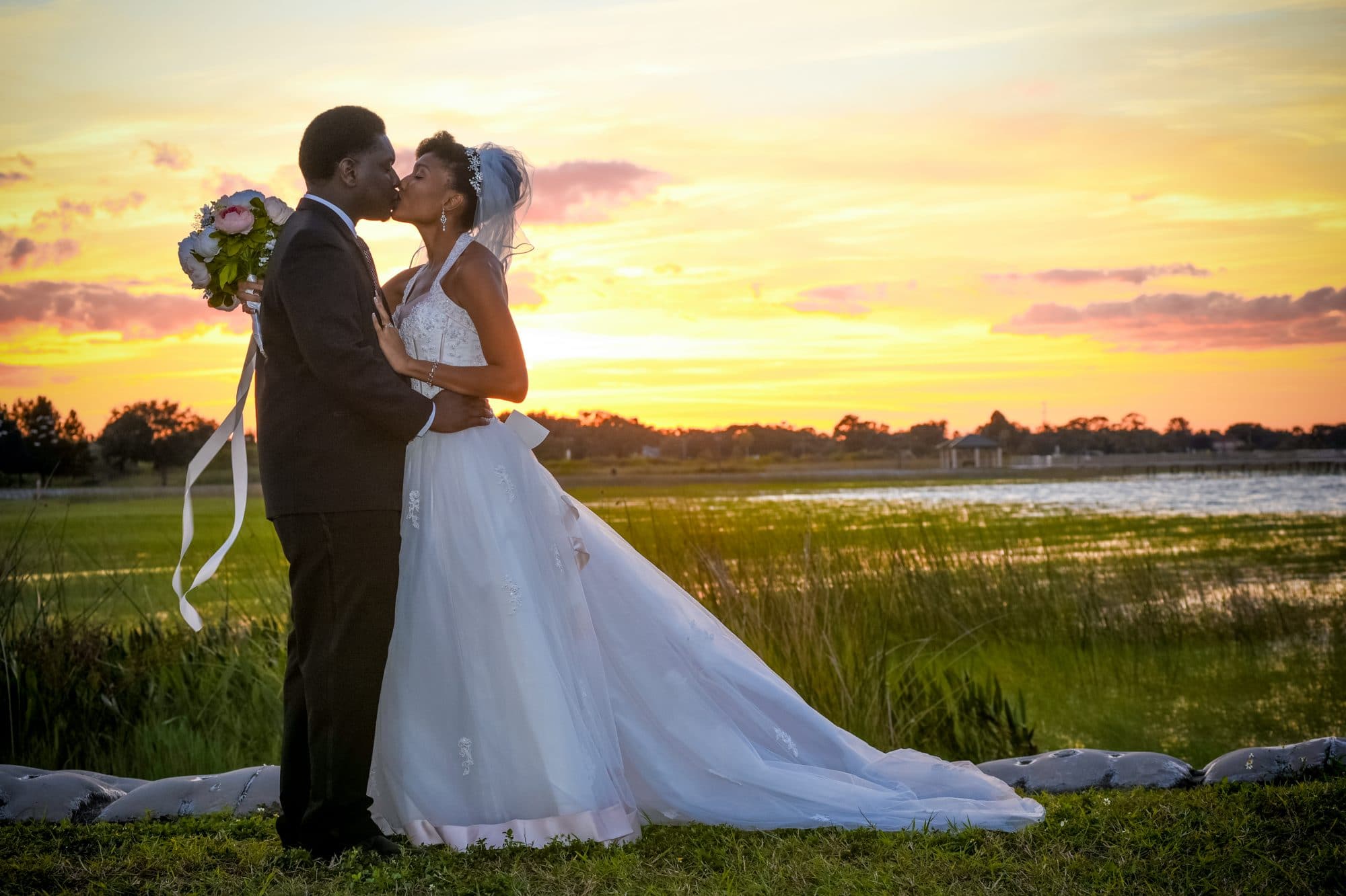 Chris Gillyard Photography - bride and groom kissing in wetlands at sunset