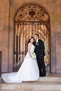Bride and Groom standing in front of elegant gate on steps, Orlando, FL