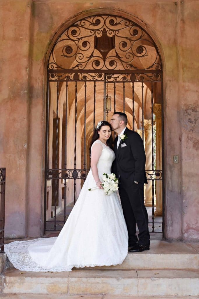 Rhodes Studios Photography and Video -Bride and Groom standing in front of elegant gate on steps