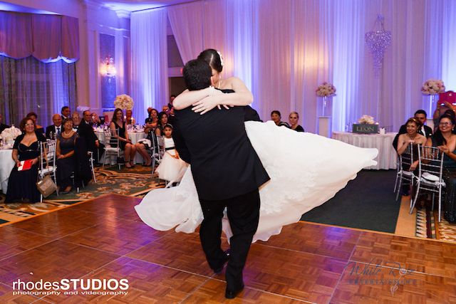 groom swinging bride around on a dance floor
