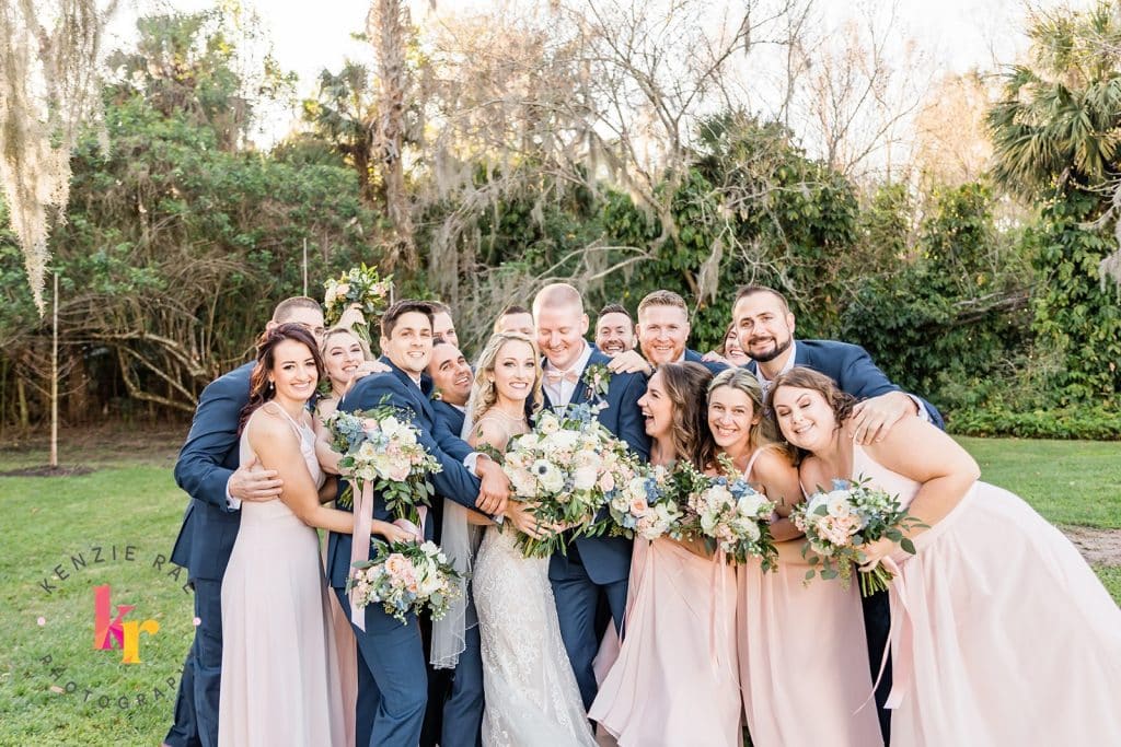 bridal party with blue suits and pink dresses and white bouquets by Bluegrass Chic