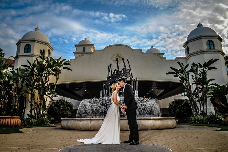 bride and groom kissing in front of hard rock hotel orlando with fountain and guitar sculpture - chris gillyard wedding photo