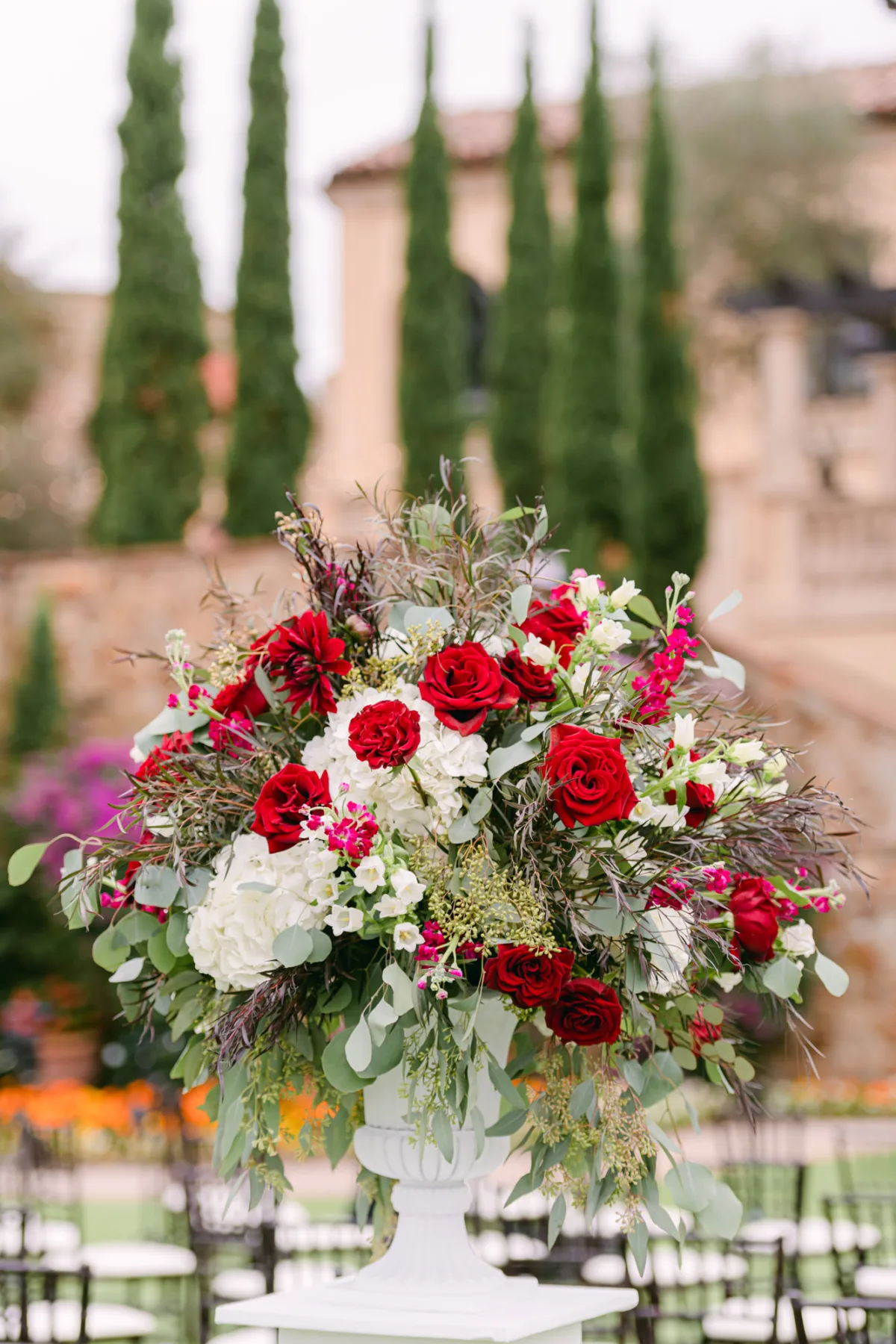 Wedding ceremony floral arrangement with red roses, white flowers, and greenery at Bella Collina in Montverde, Florida.