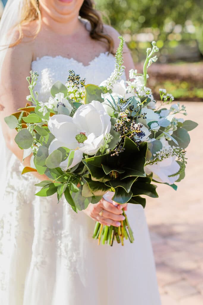 bride holding a large flower bouquet prepared by The Flower Studio