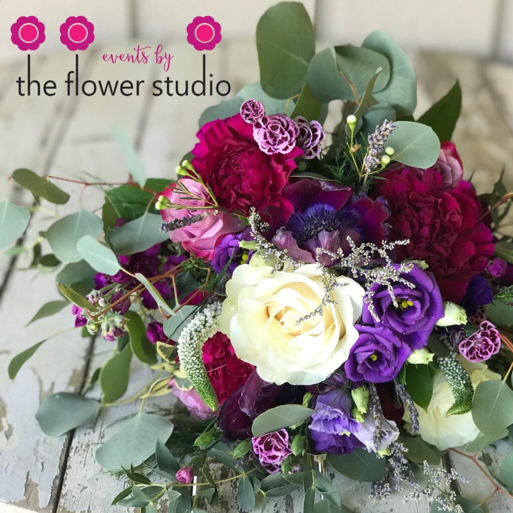 large flower arrangement with white, purple, and maroon flowers prepared by The Flower Studio