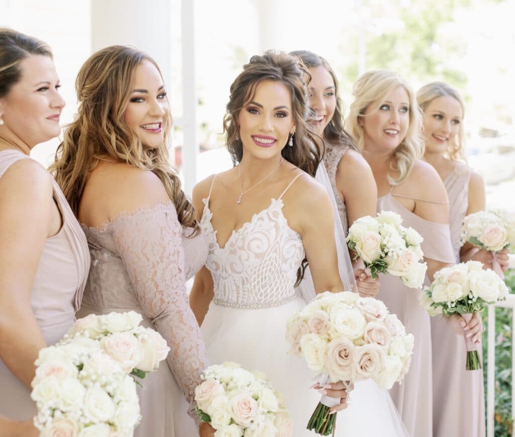 bride and bridesmaids holding white flowers by kristy's artistry design team