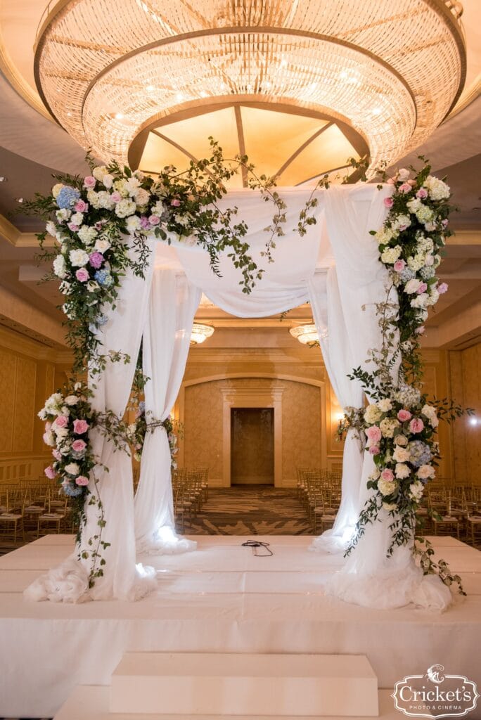raised platform covered with flowers and white linens for wedding ceremony