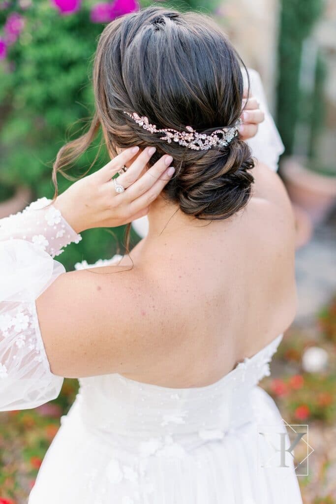 bride adjusting her headpiece while in a dress from Solutions Bridal