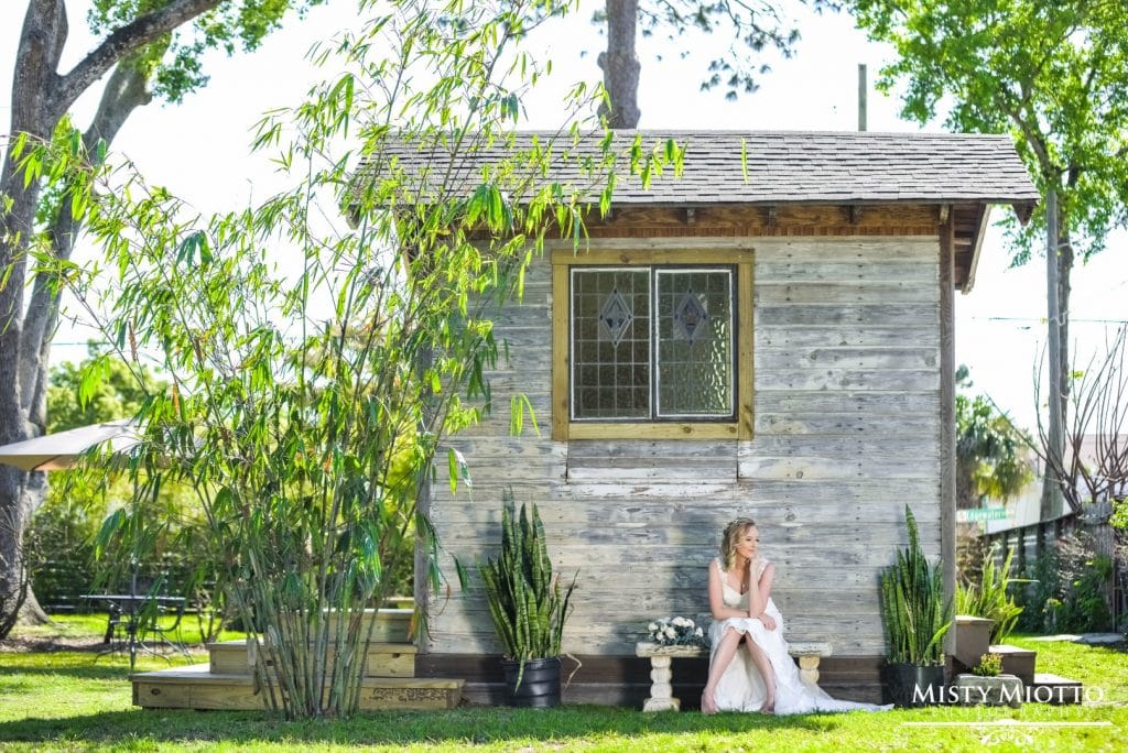 Live-Love-Laugh-Events-Bride sitting on old wooden bench outside small wooden house