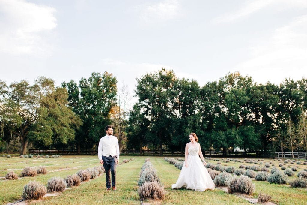 Live-Love-Laugh-Events-Bride and Groom walking outside in a field of plants