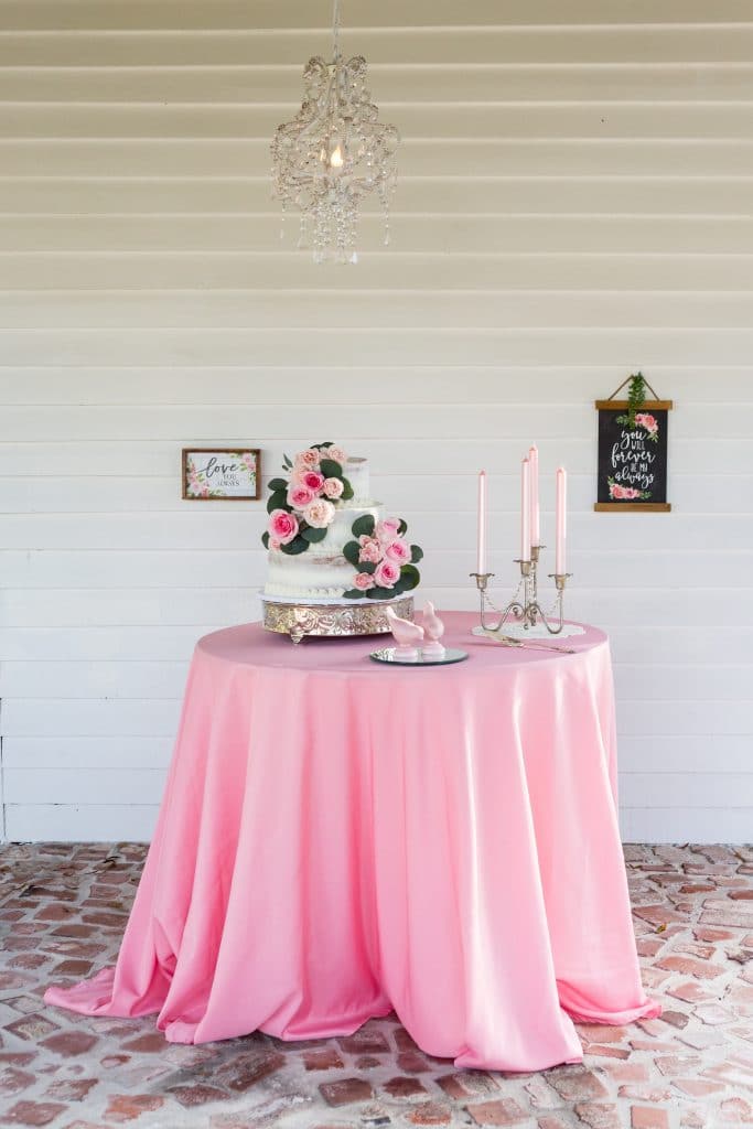C Squared Events - pink draped table with wedding cake at candelabra