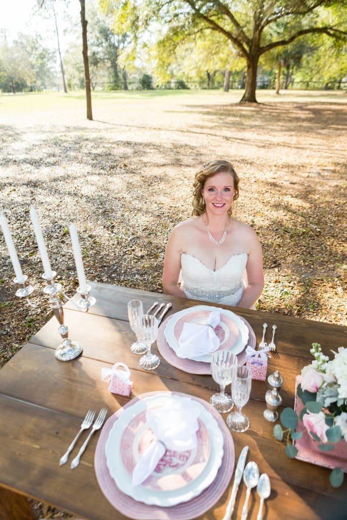 C Squared Events - Bride sitting at rustic outdoor reception table