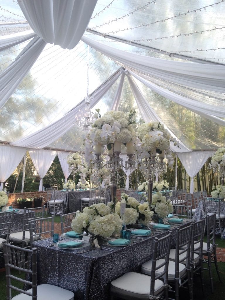 Connie-Duglin-Linen-Silver sequin linen, silver chairs, tiffany blue napkin accetns and large white floral centerpiece under white sheer fabric overhead