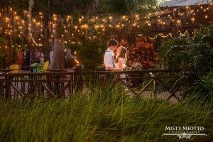 Paradise Cove - young couple kissing on bridge in tropical setting