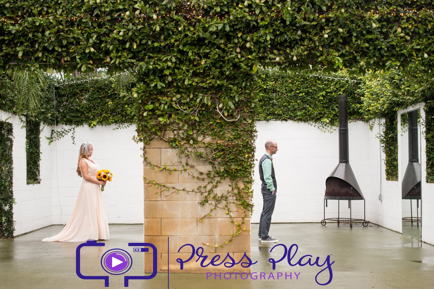 Press Play Entertainment - bride and groom in vine covered roofless courtyard for first look