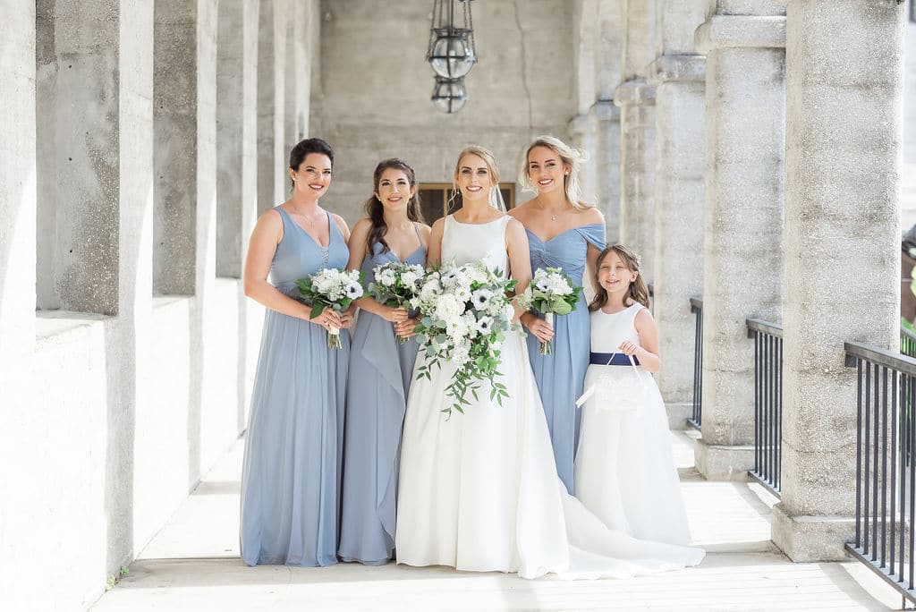 bride with white flowers and bridesmaids in blue dresses - orlando wedding planner