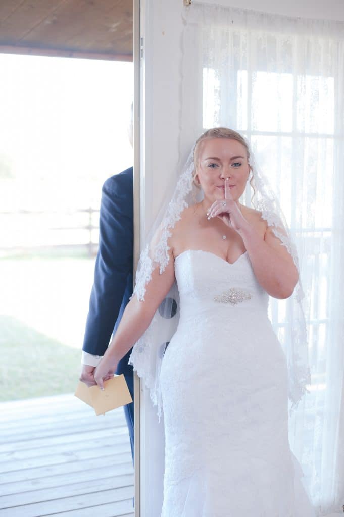 Brittany and Todd on opposite sides of door passing a note.