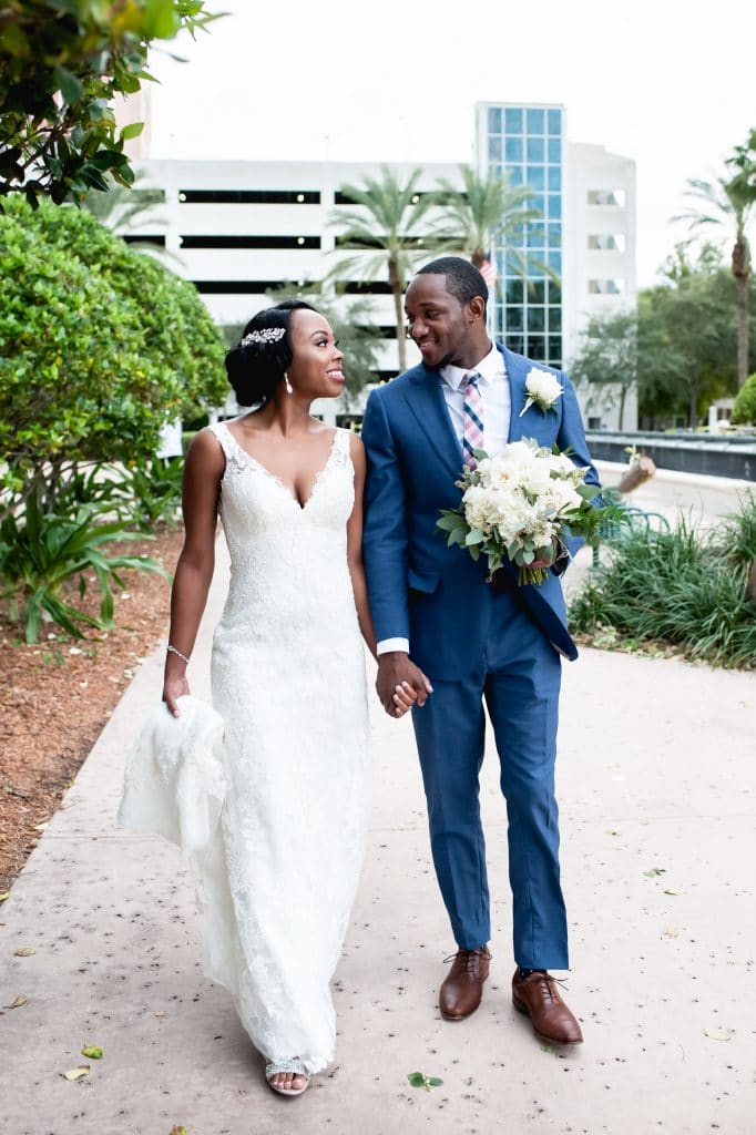 Embrace by Kara - beautiful bride and groom walking on sidewalk