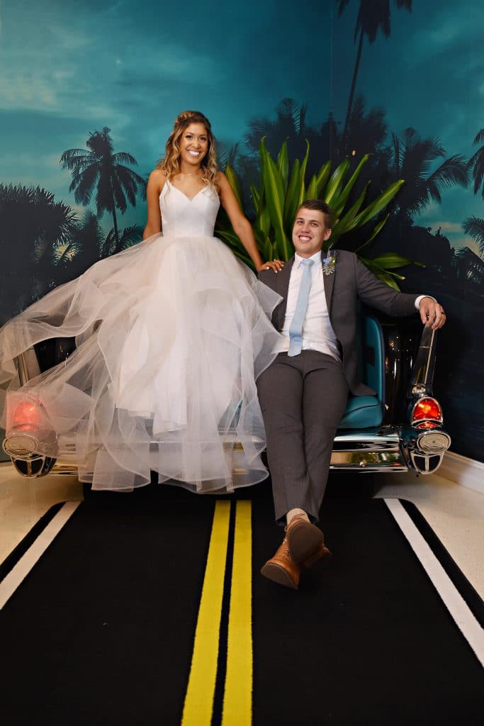 Bride and groom in couch shaped like a retro car.