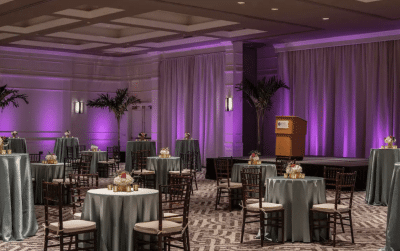 Hyatt-Regency-Orlando-Intnl-Airport-Indoor reception with small round tall tables and beautiful purple uplighting on walls