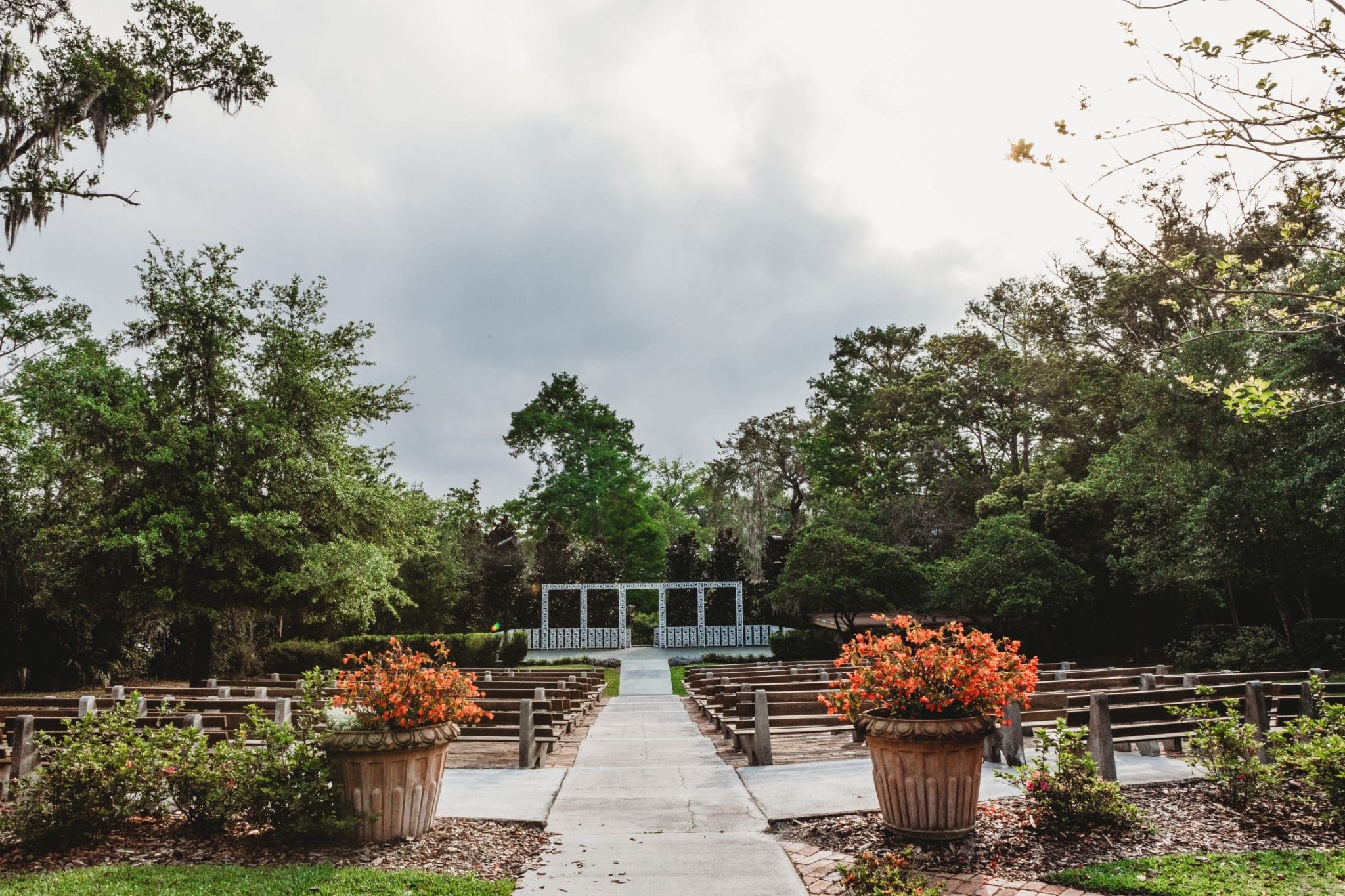 wedding ceremony venue in garden setting with wood benches and white trellis at Azalea Lodge at Mead Botanical Garden