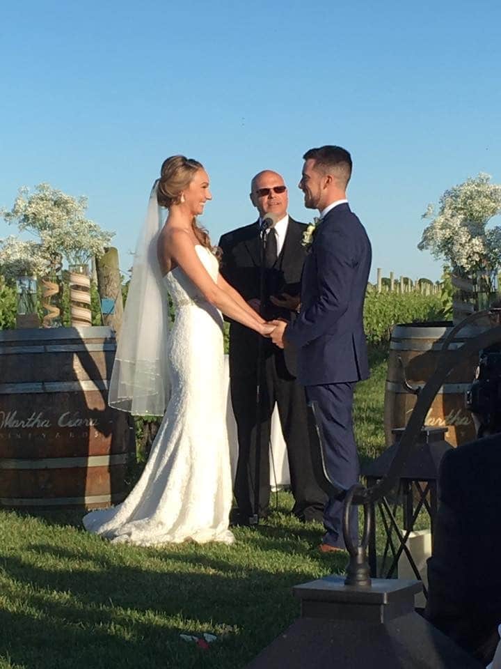 Pastor-Mike-Weddings-Bride and groom standing hand in hand facing each other outdoors at winery.
