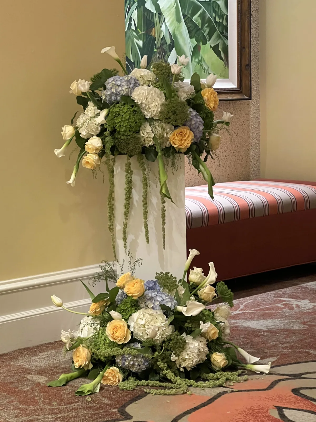 white pillar with yellow and white floral arrangements for wedding