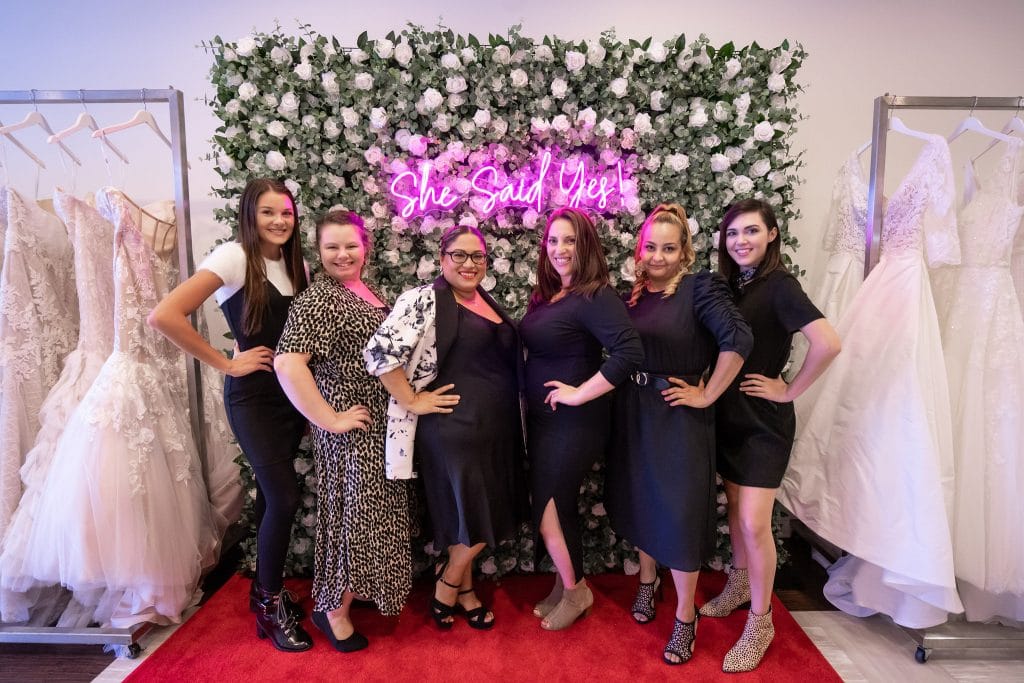 6 women in front of flower wall with neon sign at bridal salong