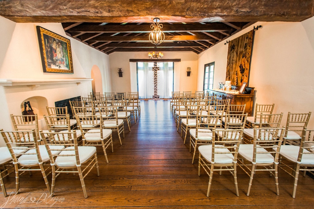 wedding ceremony venue with hardwood floors and gold chivari chairs with wood beam ceiling at casa feliz