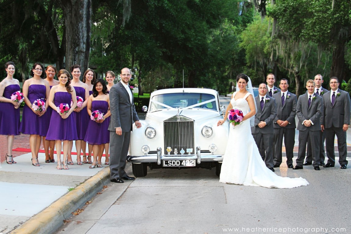 bride & groom with bridal party standing next to vintage car