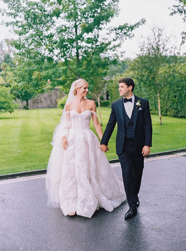 bride who customized her wedding dress by added sleeves with groom outside in front of trees