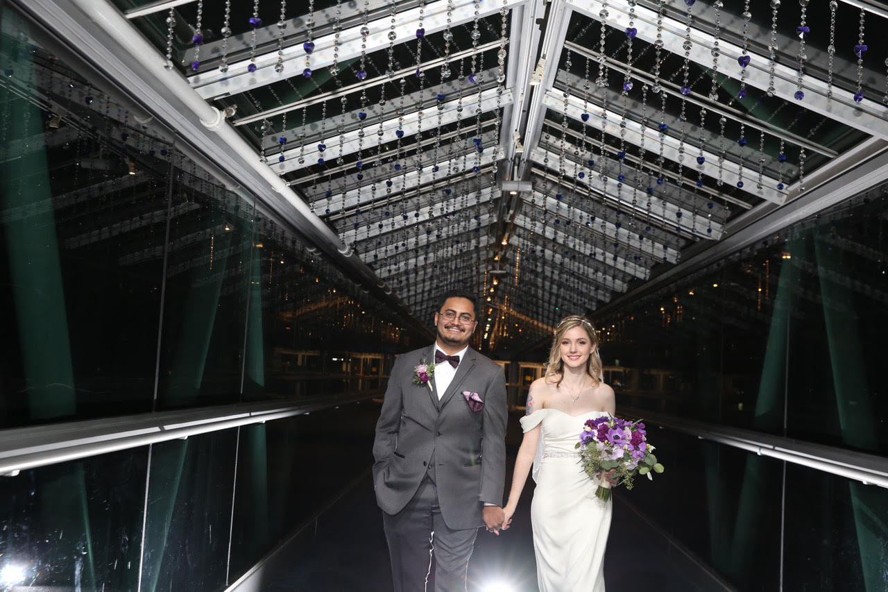 Live Happy Studio - bride & groom standing in covered walkway of venue