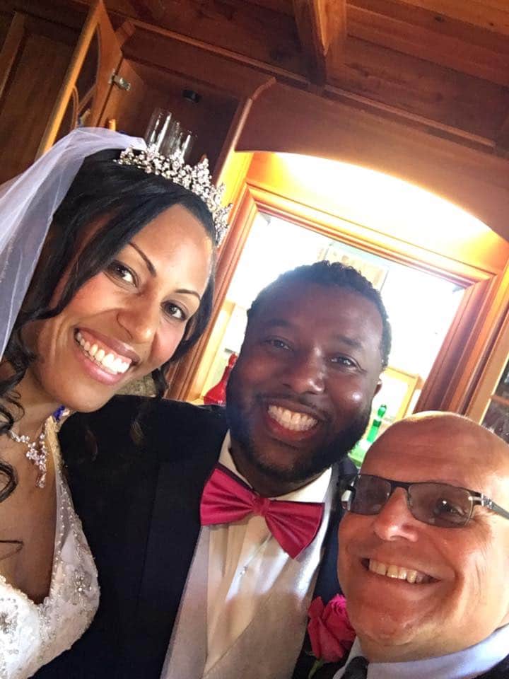 Pastor Mike posing with bride and groom