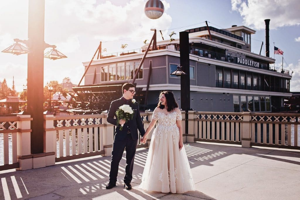 wedding couple standing on the dock, riverboat behind them, sun shining, Elope to Orlando, Orlando, FL
