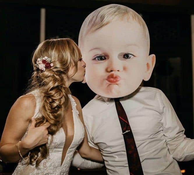 Great wedding DJ- bride kissing a person that has a giant baby head put on their body