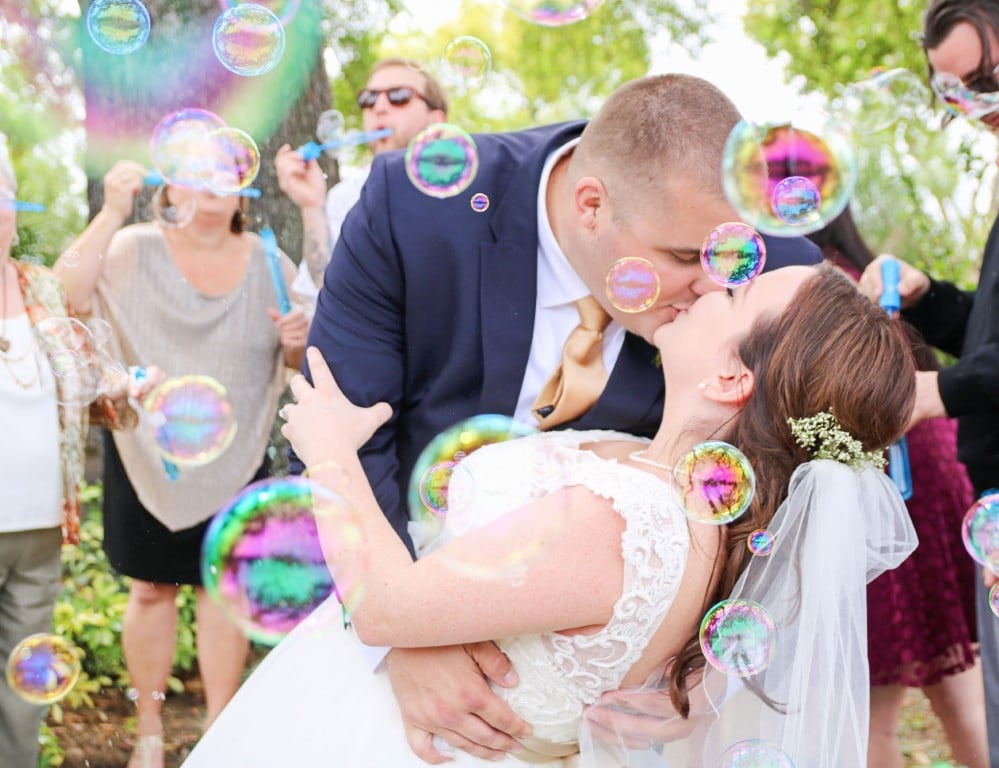 Honeywood Photography photo of groom dipping his bride and kissing her as bubbles float around them