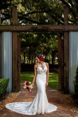 bride with her bouquet standing at the gate entrance to the wedding venue, Orlando, FL