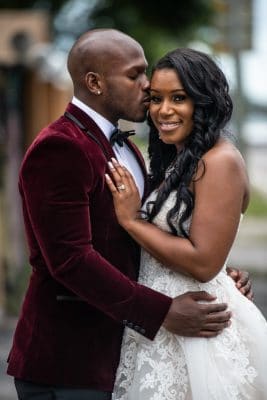 black couple on their wedding day, groom kissing his bride on her cheek, Orlando, FL