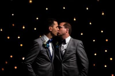 two men in tuxedos on their wedding day, black background with stars, Orlando, FL