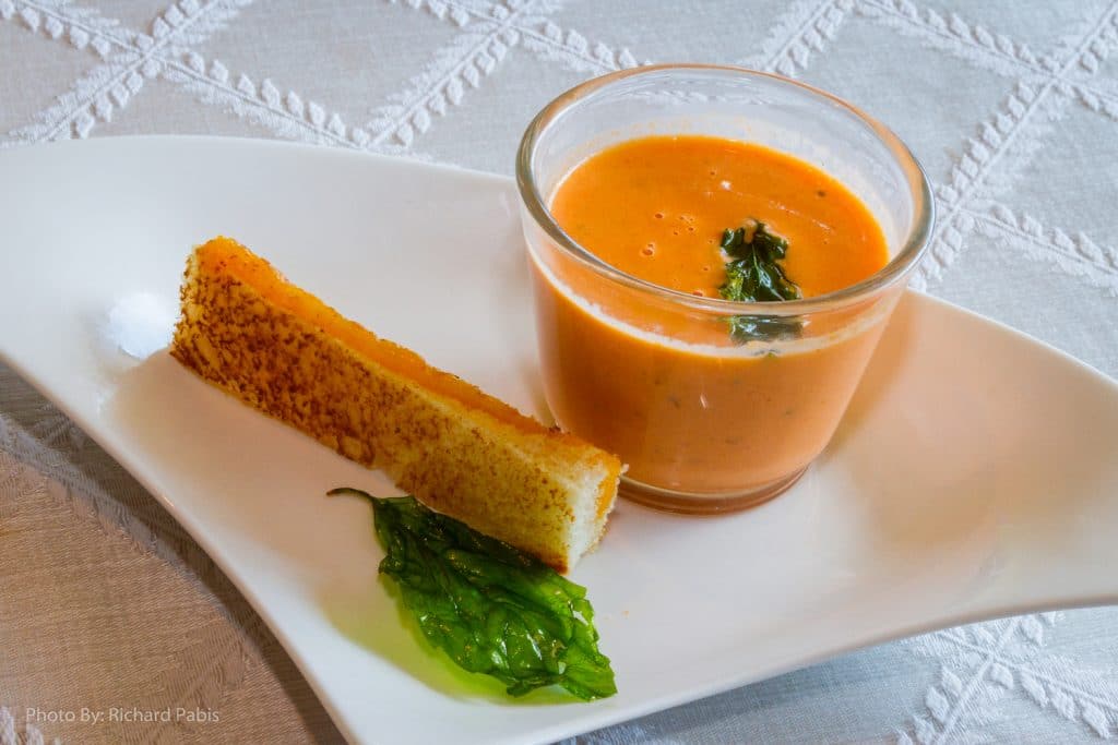 individual portion of delicious tomato bisque soup and crusted bread by Foodie Catering