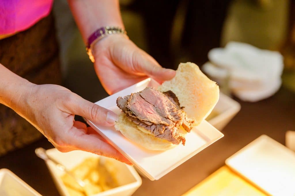 close up of person making a sandwich at a wedding reception