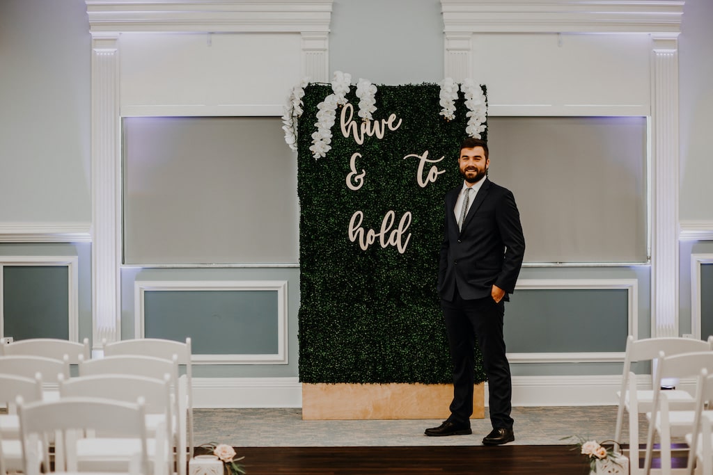 Barney E. Veal Center groom standing in front of alter