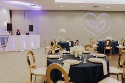 Barney E. Veal Center tables set up for wedding reception with DJ in the corner and image projected onto wall