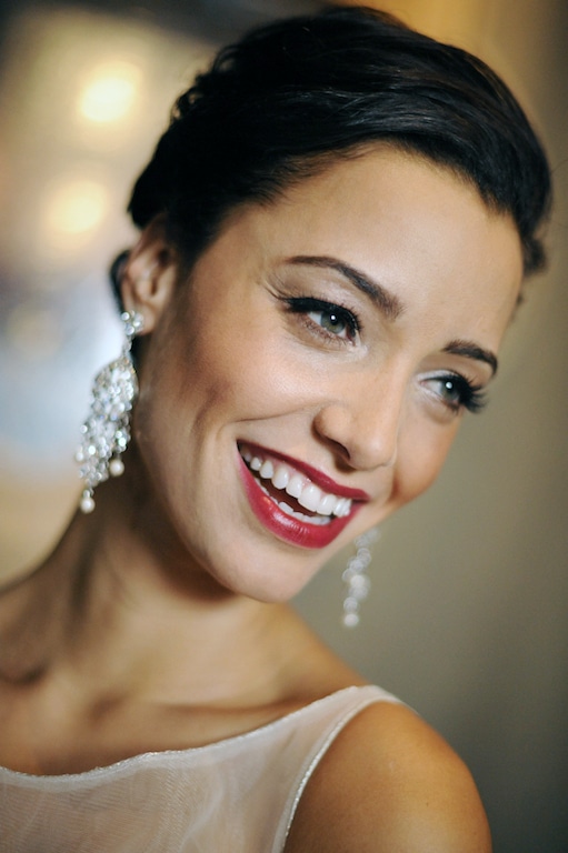 Beauté Spécialé Bride with red lipstick and dangling earrings smiling